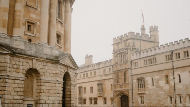 Historic university buildings with a grassy courtyard.